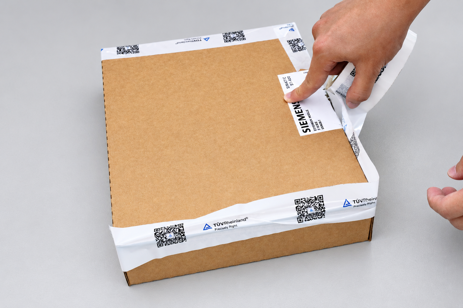 Applying T&Uuml;V Rheinland tamper-evident tape to the Siemens carton
