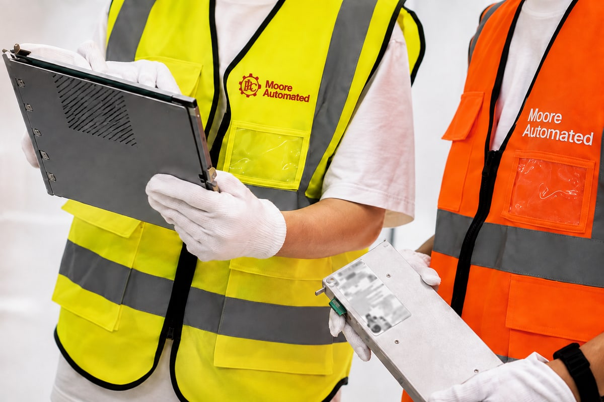 Staff reviewing a tablet and an automation component